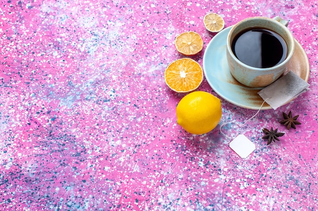 Tazza di tè al limone con vista dall'alto sulla scrivania rosa.