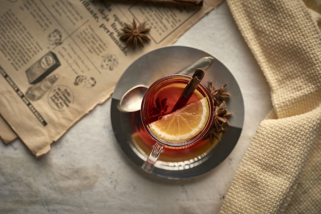 Tazza di tè con bastoncini di cannella al limone e chiodi di garofano