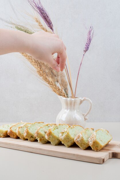 Tazza di tè e fette di torta al pistacchio sulla superficie bianca