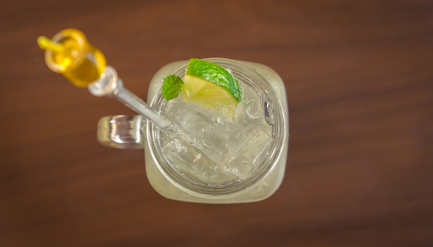 Tazza di vetro con bevanda con ghiaccio e limone