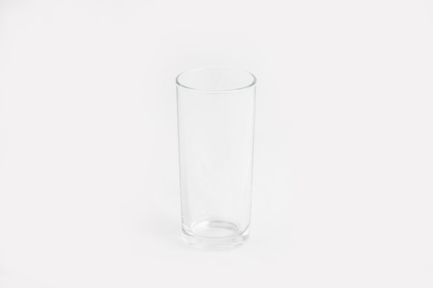 Tazza di vetro trasparente elegante isolata su una parete bianca