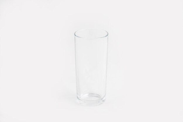 Tazza di vetro trasparente elegante isolata su una parete bianca