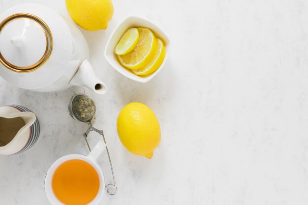 Tazza e bollitore di tè del limone con lo spazio della copia