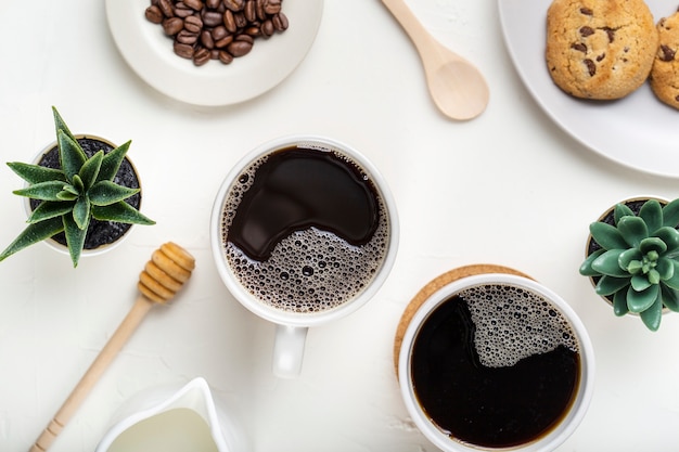 Tazze da caffè piatte con piante