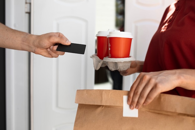 Tazze di caffè della holding della donna di vista laterale