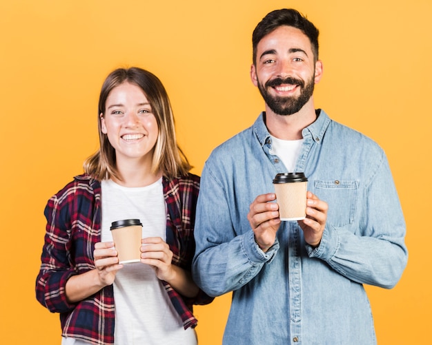 Tazze di caffè della tenuta delle coppie del colpo medio