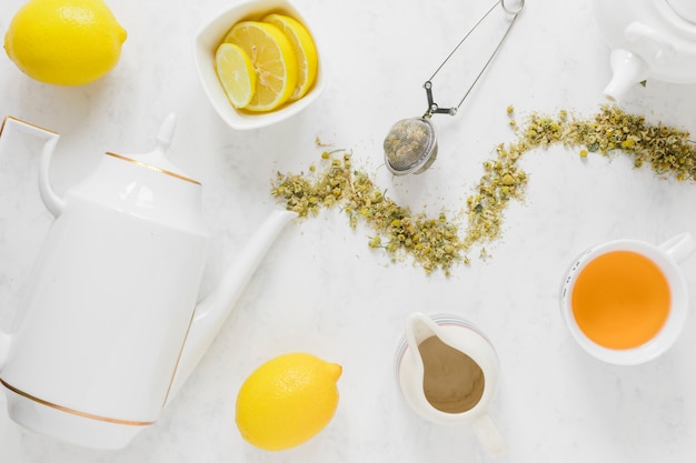 Tè al limone con bollitore e foglie secche