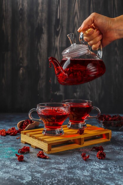 Tè caldo all'ibisco in una tazza di vetro e una teiera di vetro.