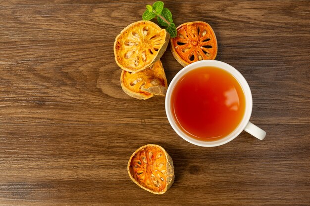 Tè caldo secco alla frutta bael in una tazza di erbe tailandesi