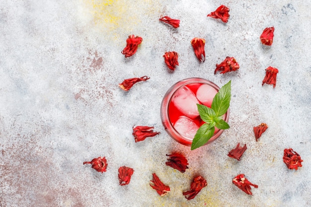 Tè freddo all'ibisco con ghiaccio e foglie di basilico.