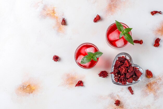 Tè freddo all'ibisco con ghiaccio e foglie di basilico.