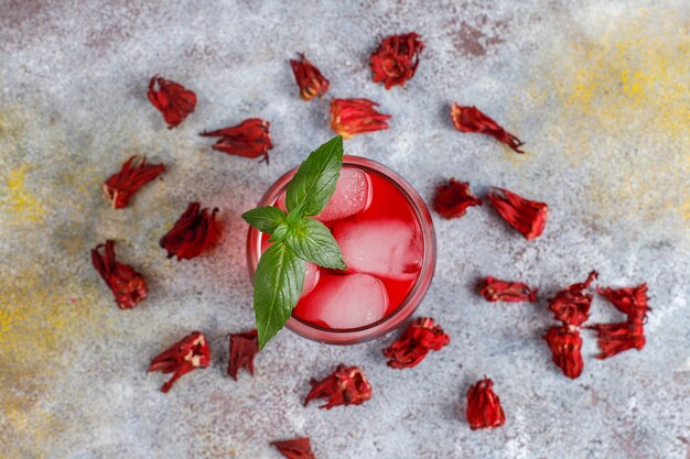 Tè freddo all'ibisco con ghiaccio e foglie di basilico.