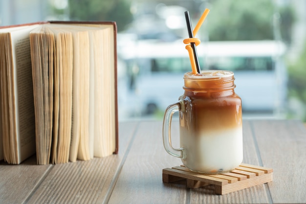 Tè freddo con salsa al caramello e latte nel barattolo sul tavolo