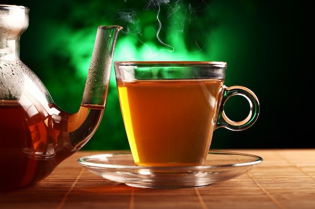 Tè verde caldo in teiera e tazza di vetro