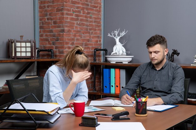 Team d'ufficio impegnato e stanco che fa brainstorming su un problema importante nell'ambiente dell'ufficio