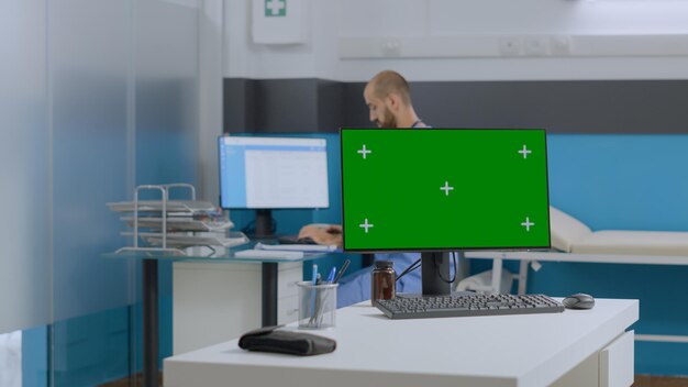 Team multietnico che discute i sintomi della malattia analizzando il documento medico che lavora al trattamento sanitario nell'ufficio ospedaliero. Mock up computer chroma key con schermo verde con display isolato