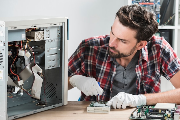 Tecnico maschio che lavora al computer rotto