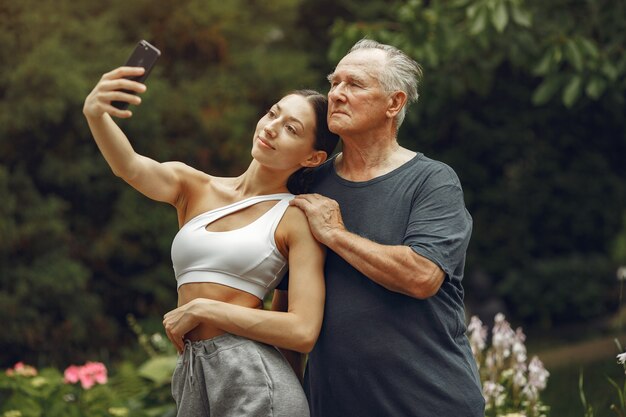 Tecnologia, persone e concetto di comunicazione. Uomo maggiore al parco estivo. Nonno con nipote.