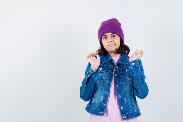 Teen donna in camicia a scacchi e berretto gesticolando isolato