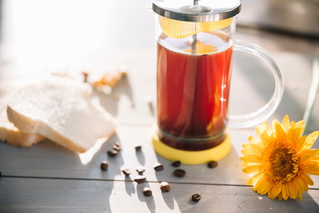 Teiera con toast e fiori sul tavolo