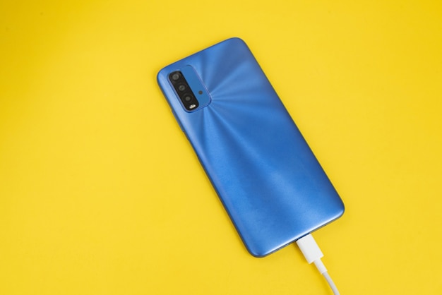 Telefono cellulare blu collegato al tipo di cavo USB - In carica