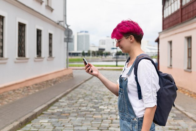 Telefono della tenuta della ragazza di vista laterale