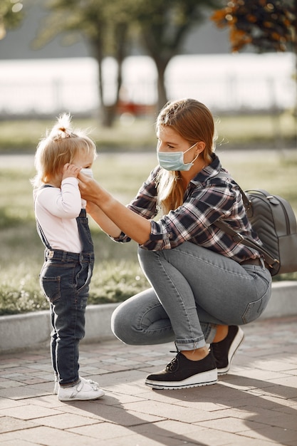 Tema Coronavirus. Famiglia in un parco estivo. Donna in una camicia di cella.