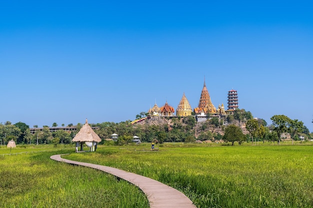 Tempio della grotta della tigre Wat Tham Suea a Kanchanaburi Thailandia con campo di riso verde in una giornata di sole