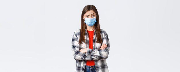 Tempo libero per l'epidemia di coronavirus in quarantena concetto di distanza sociale ed emozioni Scioccata e confusa giovane bella ragazza adolescente sente strane notizie alzare le sopracciglia perplessa indossare una maschera medica