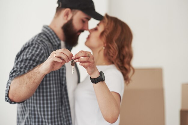 Tenendo le chiavi. Coppia felice insieme nella loro nuova casa. Concezione del movimento