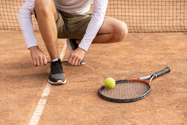 Tennis che lega le sue scarpe