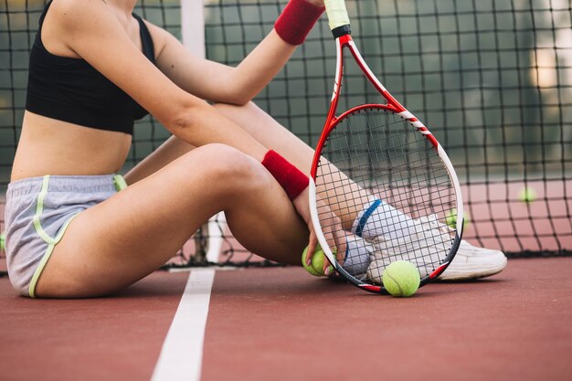 Tennis del primo piano che si siede sul pavimento