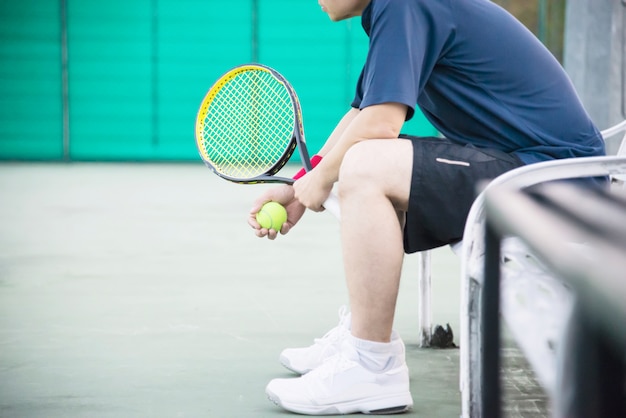 Tennista triste seduto in campo dopo aver perso una partita