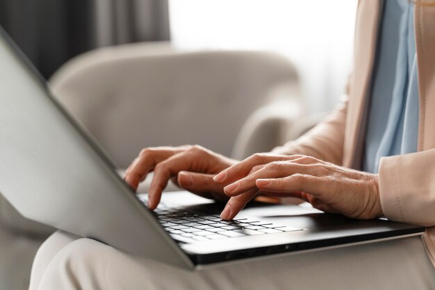 Terapista della donna del primo piano che per mezzo del computer portatile