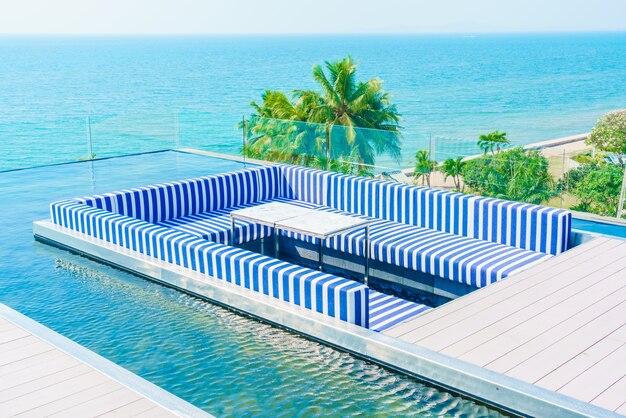 Terrazza con blu e poltrone bianche e una piscina intorno