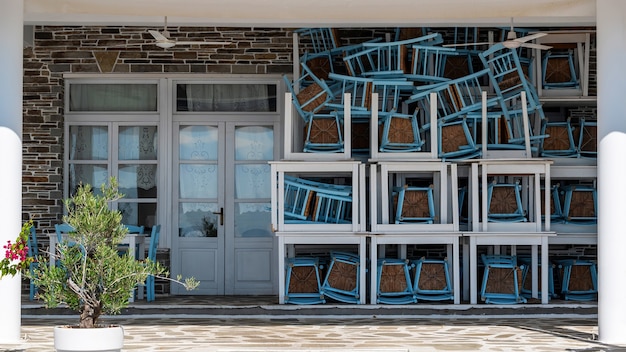 Terrazza di un ristorante con sedie e tavoli assemblati, piccolo albero davanti all'ingresso a Nikiti, Grecia