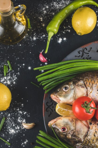 Testa di pesce con erbe aromatiche, limone e pomodori