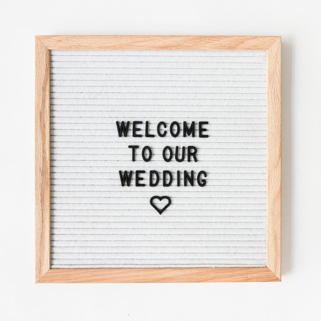 Testo di benvenuto per il matrimonio sulla cornice in legno su sfondo bianco