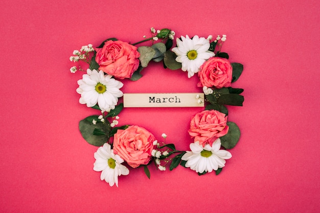 Testo di marzo dentro i fiori bianchi e foglia decorata sul contesto rosso