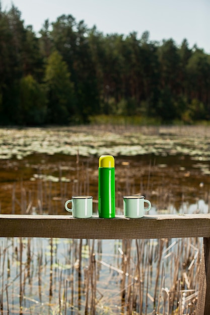 Thermos con due tazze preparato per la giornata in campeggio