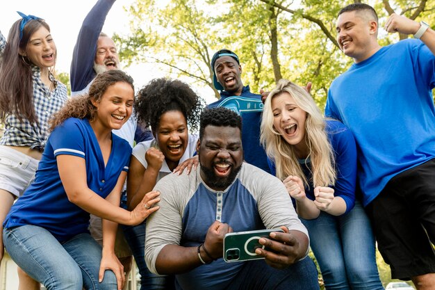 Tifosi che guardano la propria squadra vincere la partita su un telefono cellulare