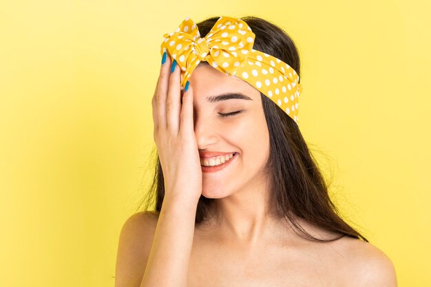 Timida bella ragazza sorridente e tenendo la mano sul viso Foto di alta qualità