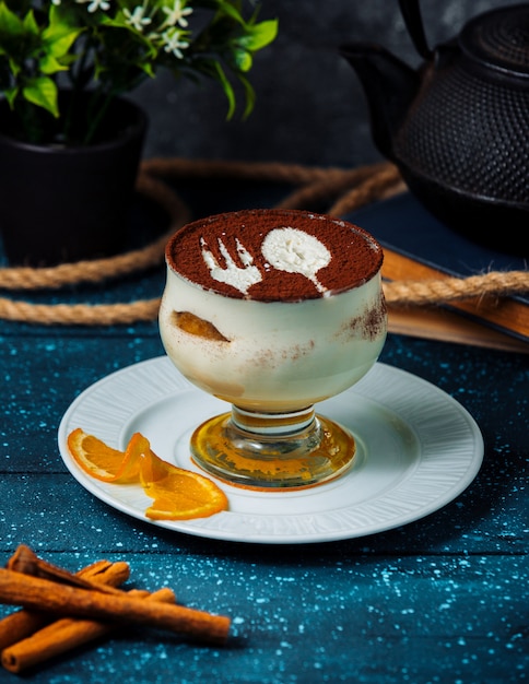 Tiramisù a tazza con cacao in polvere e bastoncini di cannella