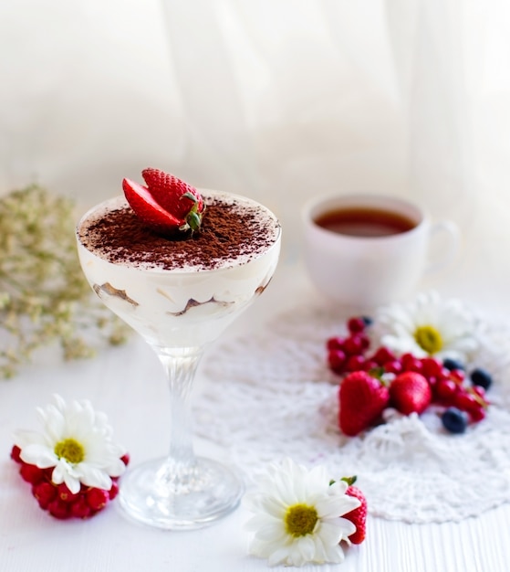 Tiramisù italiano guarnito con fragole, servito con tè