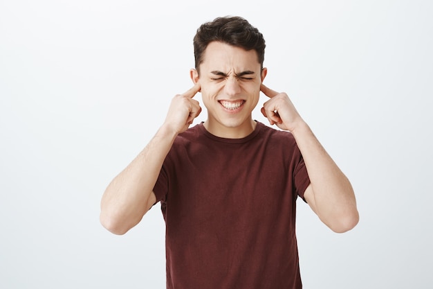 Tiro al coperto del modello maschio europeo dispiaciuto in t-shirt casual