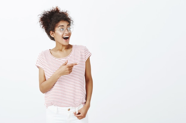 Tiro al coperto di donna colpita con acconciatura afro in posa in studio