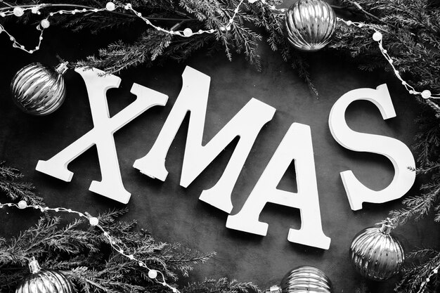 Titolo di Natale tra rami di conifere, lucine e palle ornamentali
