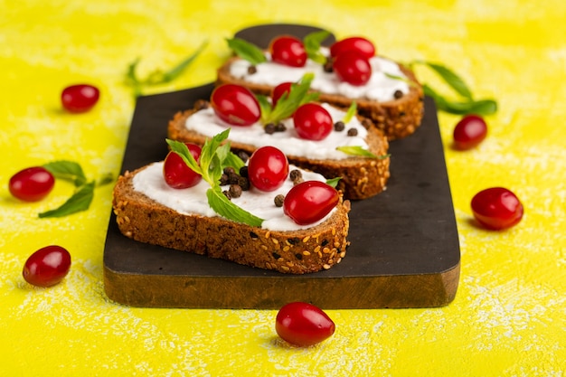 Toast di pane vista ravvicinata frontale con panna acida e cornioli su giallo