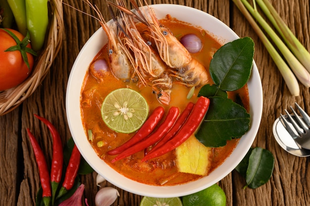 Tom Yum Kung Thai piccante zuppa di gamberi con citronella, limone, galanga e peperoncino sul tavolo di legno, cibo in Thailandia