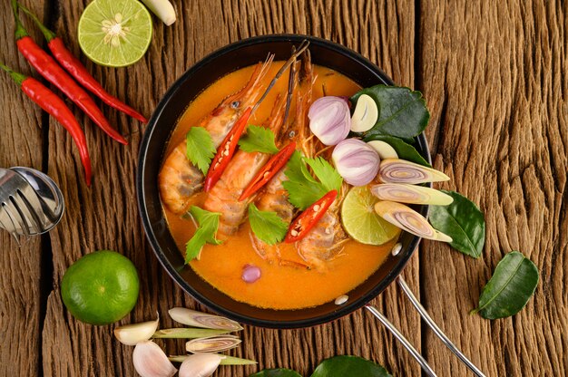 Tom Yum Kung Thai piccante zuppa di gamberi con citronella, limone, galanga e peperoncino sul tavolo di legno, cibo in Thailandia